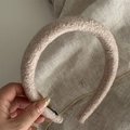 Detail of pink boucle fabric headband with non-slip black inner lining for comfort - Beige