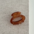 Detail view of amber acetate hair claw with France handmade engraving on linen - Hollow Small Oval - Coffee