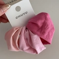 Close-up of four gradient pink elastic hair scrunchies with soft matte fabric texture - Pink