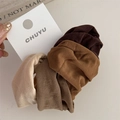 Close-up of earth tone elastic hair ties in beige and brown on a display card - Brown
