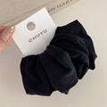 Detailed view of a soft black fabric hair scrunchie with knit texture and CHUYU card label - Black