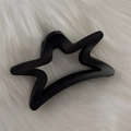 Gros plan détaillé d'une pince à cheveux noire mate en forme d'étoile sur fond de fausse fourrure - Noir Mat - Étoile