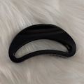 Gros plan d'une pince à cheveux noire mate évidée montrant la texture sur peluche blanche - Noir Mat - Éventail