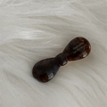 Detail of a brown acetate tortoiseshell bow hair clip with Barrette La France lettering - Blue Coffee