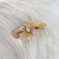 Dettaglio di un piccolo fermaglio per capelli a fiore in acetato con strass su pelliccia - Giallo Rosa