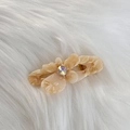 Dettaglio del fermaglio per capelli in acetato ambrato con gemma lucida e logo Amy Bear - Albicocca