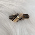 Detail of floral hair clip with amber pattern and crystal centered on soft fur background - Striped