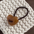 Close-up of a brown heart resin pendant on a high-elastic ponytail hair tie - Brown