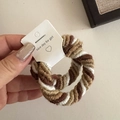 Detail of three-color braided hair ties in coffee and cream tones held by hand - Apricot Coffee Woven