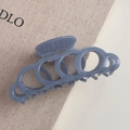 Détail de la pince à cheveux bleue avec anneaux entrelacés et logo imprimé doré - Boucle Creuse / Bleu Brume