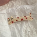 Detail of cream yellow cat hair clip with red dots on a stylish crinkled paper background - Long Cat - Spotted Pattern