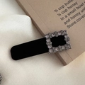 Detalle de una pinza para el pelo vintage de terciopelo negro con pedrería cuadrada - Estilo de Strass Cuadrado