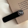 Primer plano detallado de pinza para el pelo en terciopelo negro con piedra gris - Estilo de Strass Redondo Grande