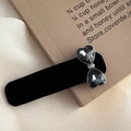 Detail of vintage grey rhinestone bow hair clip with black velvet finish on beige fabric - Large Rhinestone Bow Style