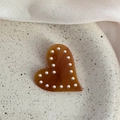 Dettaglio di un fermaglio per capelli a cuore in acetato ambrato con piccole perle bianche - Marrone