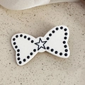 Dettaglio di un fermaglio per capelli a fiocco bianco con pois neri e stella - Bianco