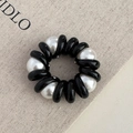 Dettaglio di elastico per capelli a spirale nero con perle bianche su tela strutturata - Perla Nera