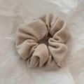 Detail of a beige ribbed knit scrunchie showcasing the soft texture and elastic pleats - Beige Textured Scrunchie