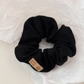 Dettaglio dell'elastico per capelli in maglia nera con etichetta fatta a mano e smiley - Nero