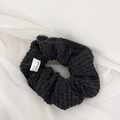 Detail of black knitted hair scrunchie with fine texture and white brand label - Hair Tie / Black