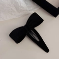 Detalle de pinza para el pelo con lazo de terciopelo negro sobre fondo minimalista - Capa Única / Negro