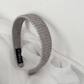 Detail of light grey ribbed knit headband featuring a brand logo tag and cozy texture - Headband / Gray