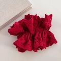 Gros plan d'un chouchou géant en dentelle rouge avec broderie anglaise détaillée - Rouge