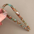 Detailed texture of marble-pattern acetate U-shaped hair fork in teal and amber finish - Green & Coffee