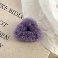 Vue macro d'un chouchou en peluche violette douce sur un fond en toile de style vintage - Pince crabe violette