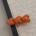 Detailansicht der bernsteinfarbenen Acetat-Haarspange mit drei Herzen und goldenem Text - Braun