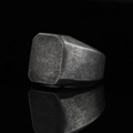 Macro detail of industrial square signet ring with vintage matte grainy texture on black mirror - Antique Silver