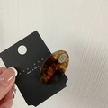 Detail of tortoiseshell acetate hair clip with golden metal plate on display card - Blue Brown