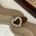 Macro shot of silver baguette-cut crystal heart jewelry on beige textured velvet - Rhinestone Heart - Coffee