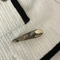Detail view of water-drop acetate hair clip with gray marble texture and gold logo - Transparent Black