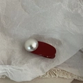 Dettaglio di un fermaglio per capelli in resina bordeaux con una grande perla bianca lucida - Stile Rotondo / Rosso