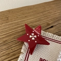 Dettaglio molletta a stella rossa con strass di cristallo su superficie in legno - Rosso Capodanno - Stella di Strass