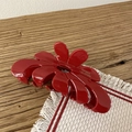 Dettaglio della pinza per capelli rossa in acetato a forma di fiore con logo fatto a mano - Rosso Capodanno - Fiore