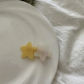 Detail showing two acetate star-shaped hair clips in yellow and marbled white finishes - Yellow Star