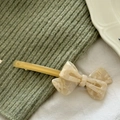 Detailed close-up of acetate bow hair clip with elegant marble texture and spring barrette - Yellow