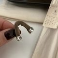 Detail of brown flocked V-shaped hair clip with sparkling rhinestones held in hand - Brown