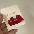 Gros plan d'une paire de mini barrettes à cheveux rouges en forme de cœur sur carte - Forme de Cœur Rouge Nouvel An / Ensemble de Styles Assortis