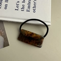 Nahaufnahme einer rechteckigen Schildpatt-Acetat-Haarspange mit hochwertiger Metallfeder - Haargummi / Blau-Braun