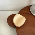 Macro shot of matte cream claw clip showing smooth finish and rounded crescent design - Round Trapezoid / Apricot