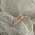 Primer plano de pinza de pelo de resina jaspeada rosa sobre fondo de papel blanco - Triángulo