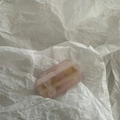 Detailed macro view of pink gradient jelly resin hair clip on white crinkle paper background - Polygon