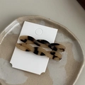 Dettaglio delle mollette in acetato tartarugato su un elegante vassoio in ceramica - Leopardo Chiaro