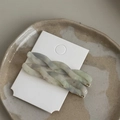 Detailed macro view of two-piece acetate twisted hair clips with marble texture on card - Smoky Blue