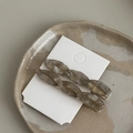 Detailed macro of a twisted acetate hair clip featuring a marble texture in beige - Transparent Gray White