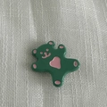Dettaglio molletta a forma di orso verde lucido con cuore rosa su tessuto bianco - Fermaglio Per Capelli Verde Lago