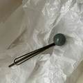 Détail d'une pince à cheveux rétro en bronze ornée d'une perle sphérique vert foncé - vert foncé